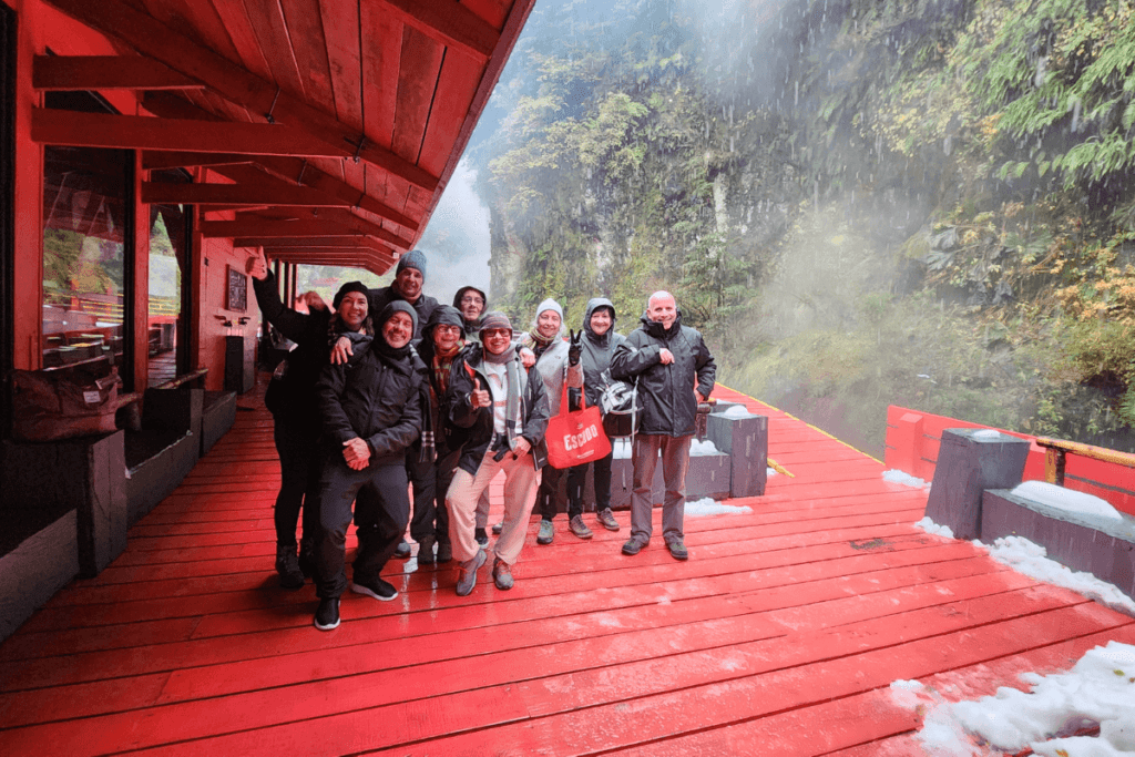 Grupo reunido no deck do quincho nas Termas Geométricas, com vista para a natureza do Parque Nacional Villarrica, Patagônia Chilena.