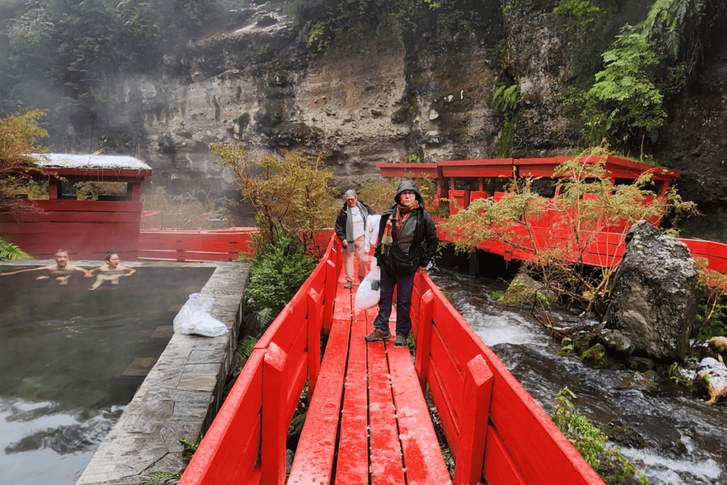 Visitantes nas passarelas e piscinas das Termas Geométricas, integradas à natureza no Parque Nacional Villarrica, Patagônia Chilena.