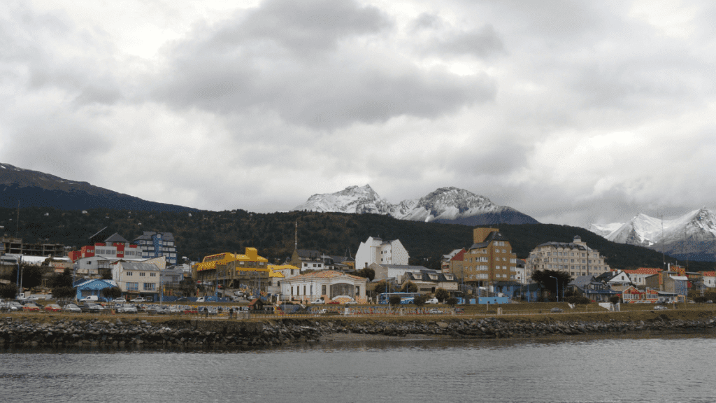 Vista parcial do centro de Ushuaia com o Canal de Beagle à frente e montanhas ao fundo.