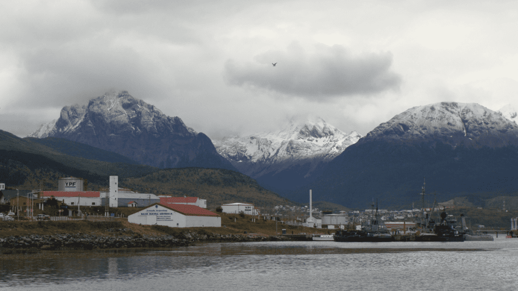 Vista do centro naval de Ushuaia com o Canal de Beagle à frente e montanhas ao fundo.