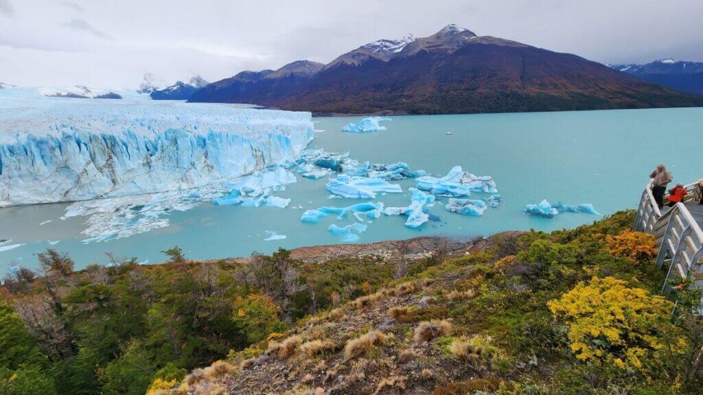 Vista lateral do Glaciar Perito Moreno em El Calafate, mostrando blocos de gelo desprendidos e variações de tons de azul