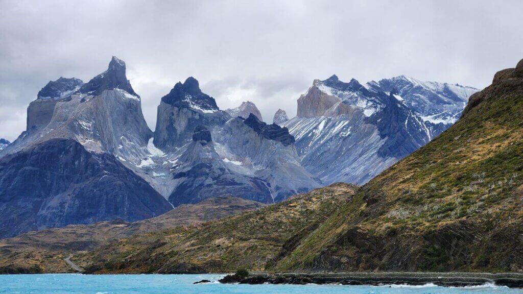 Vista frontal dos Cuernos del Paine totalmente enquadrados, com a paisagem patagônica em primeiro plano, no Parque Nacional Torres del Paine