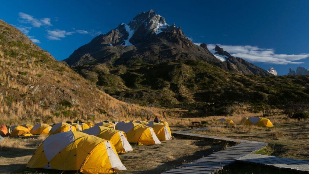 Área de camping estruturada no Parque Nacional Torres del Paine, com barracas montadas e instalações organizadas
