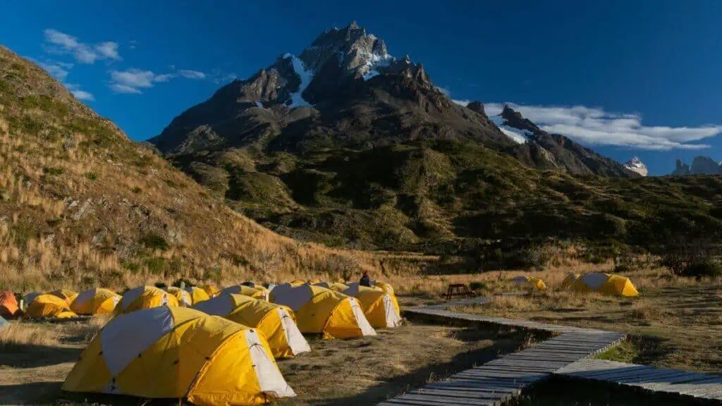 Área de camping estruturada no Parque Nacional Torres del Paine, com barracas montadas e instalações organizadas