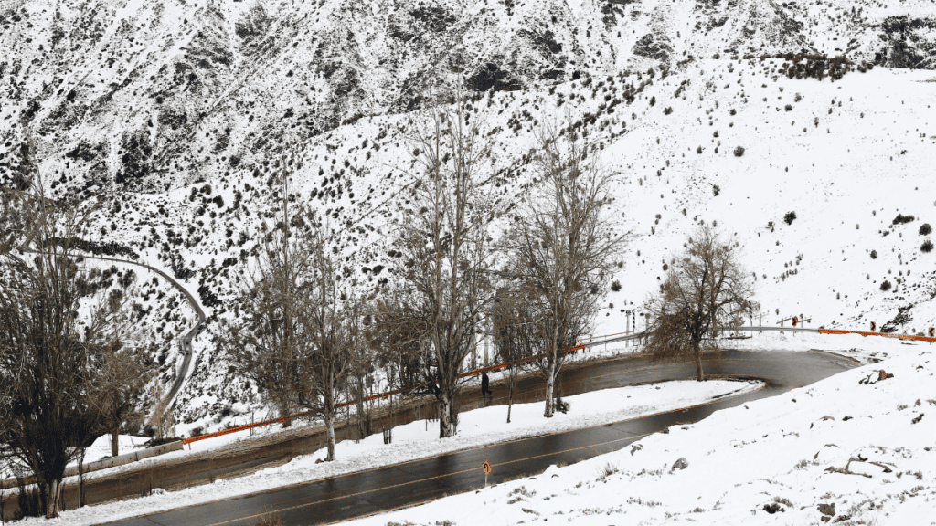 Estrada sinuosa que leva à estação de esqui de Valle Nevado, com curvas fechadas e ladeiras íngremes nas montanhas dos Andes chilenos.