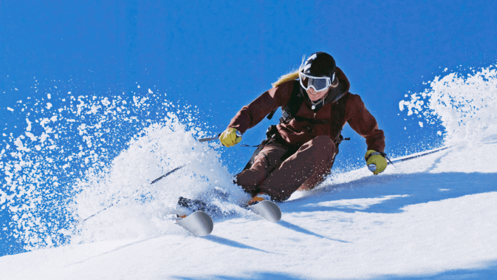 Mulher esquiando em primeiro plano na estação de esqui Cerro Perito Moreno, em El Bolsón, com montanhas da Patagônia.