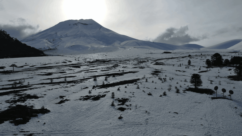 Estação de esqui de Corralco com encostas nevadas e o Vulcão Lonquimay ao fundo, na região sul do Chile.