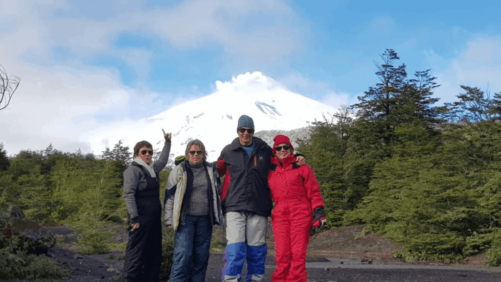 Vista do Vulcão Villarrica a partir de um mirante na estrada que leva à estação de esqui de Pucón, em dia de inverno com céu parcialmente limpo.