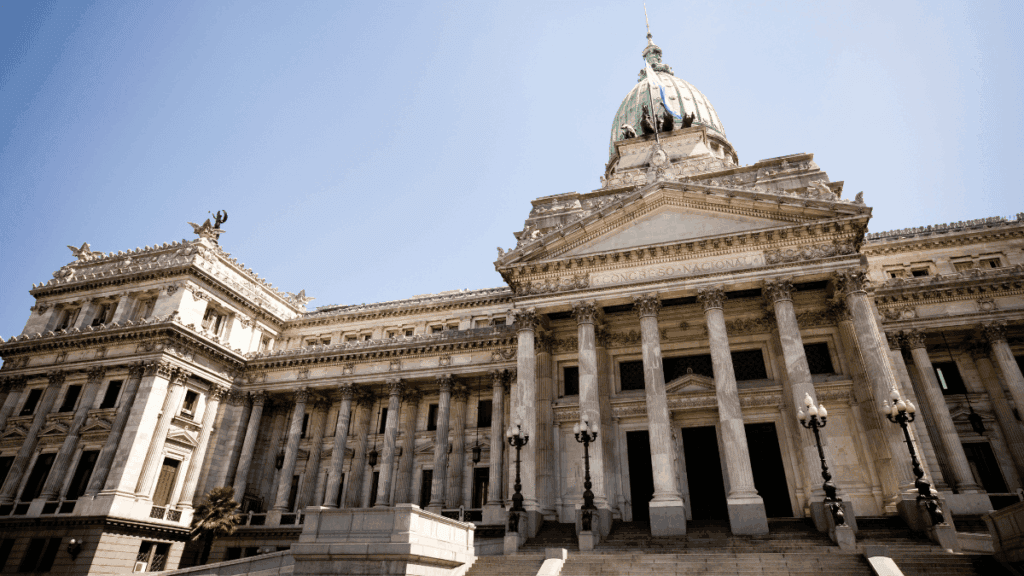 Imagem do Palácio do Congresso Argentino, um dos Palácios de Buenos Aires mais imponentes, com colunas coríntias e grande cúpula verde em estilo neoclássico.
